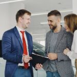 Wynajem długoterminowy a prawo: co naprawdę podpisujesz w umowie Uśmiechnięta para odbiera nowy samochód od sprzedawcy w salonie