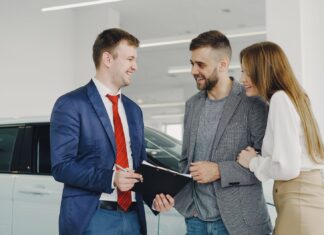 Wynajem długoterminowy a prawo: co naprawdę podpisujesz w umowie Uśmiechnięta para odbiera nowy samochód od sprzedawcy w salonie
